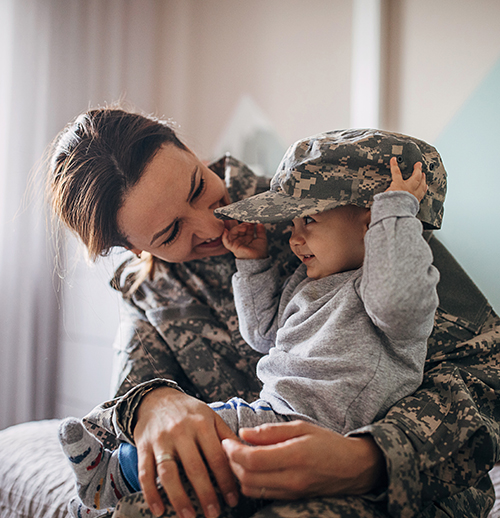 a mother in her military uniform embracing her baby son