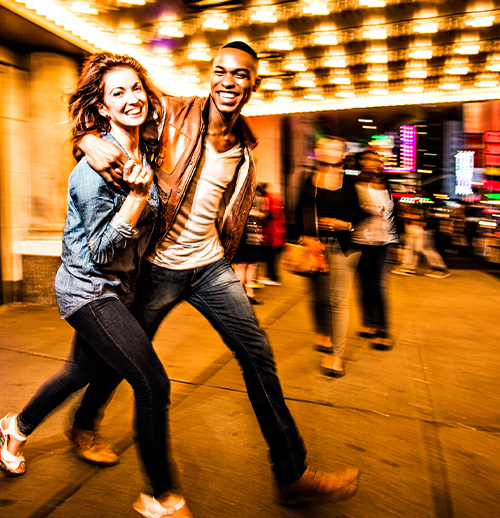 Couple smiling together as they walk around new york 
