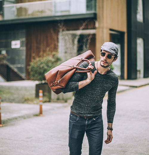 a man holding a brown leather bag