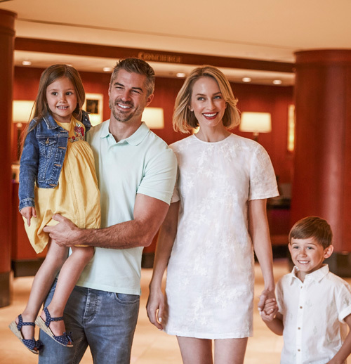 family of four walking through hotel lobby